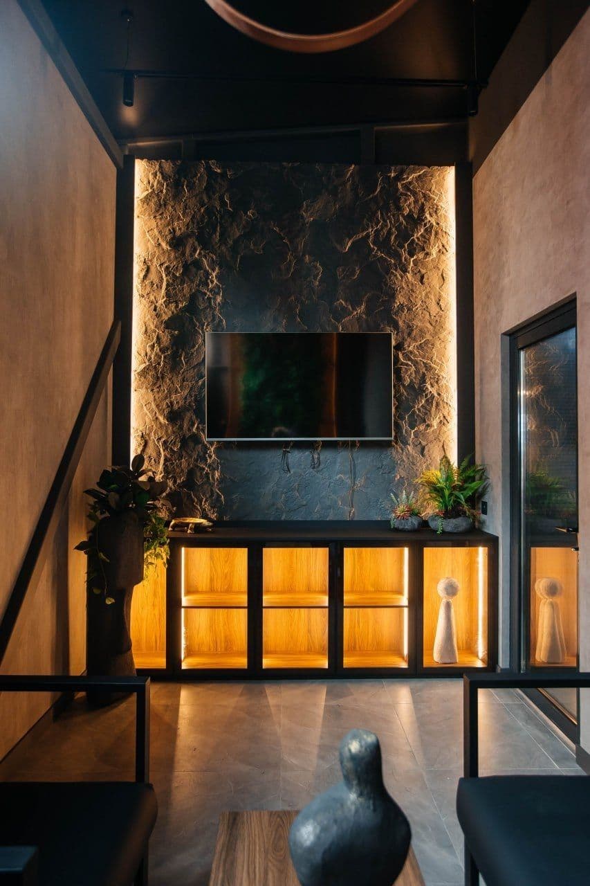 ТВ-зона с подсвеченной каменной стеной