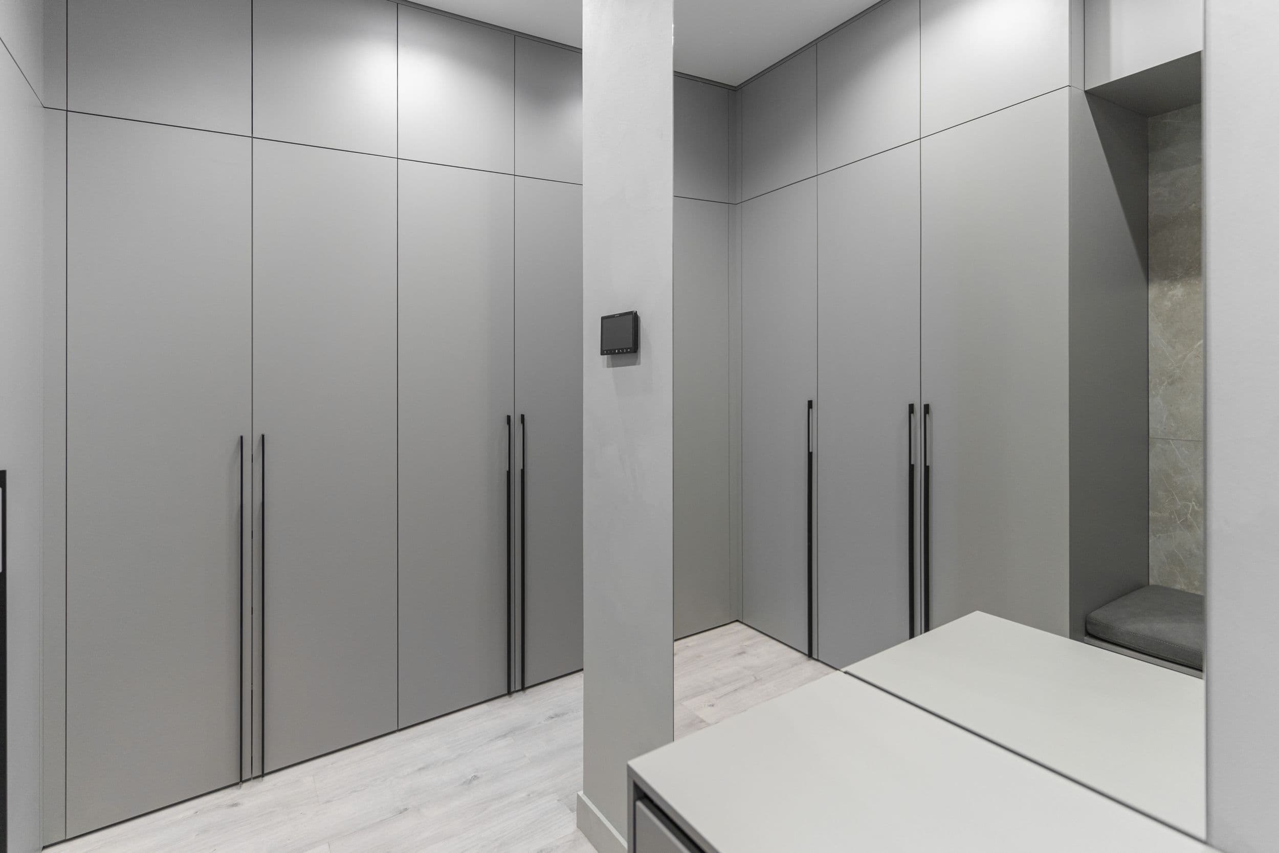 Встроенный серый шкаф с чёрными ручками